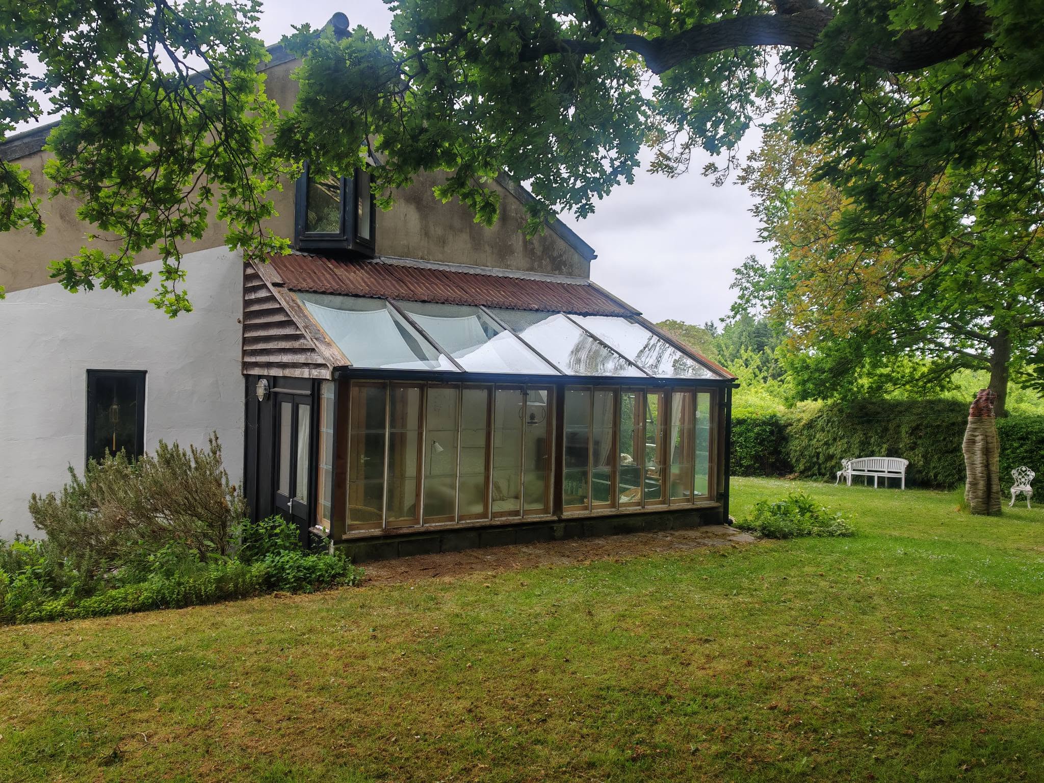 The same timber conservatory in a garden after its roof and panel clean
