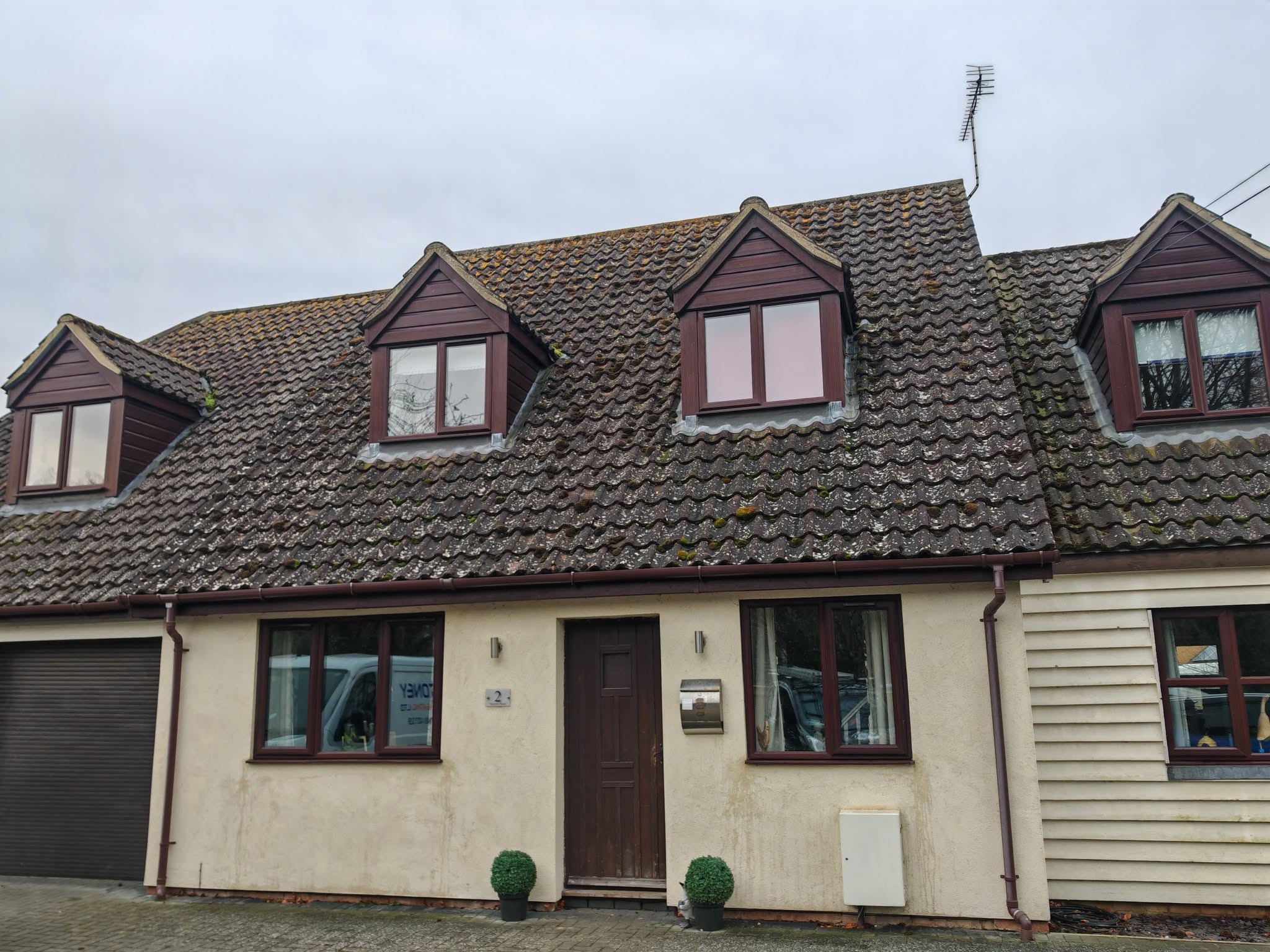 Front of a chalet bungalow with three dormer windows and a garage